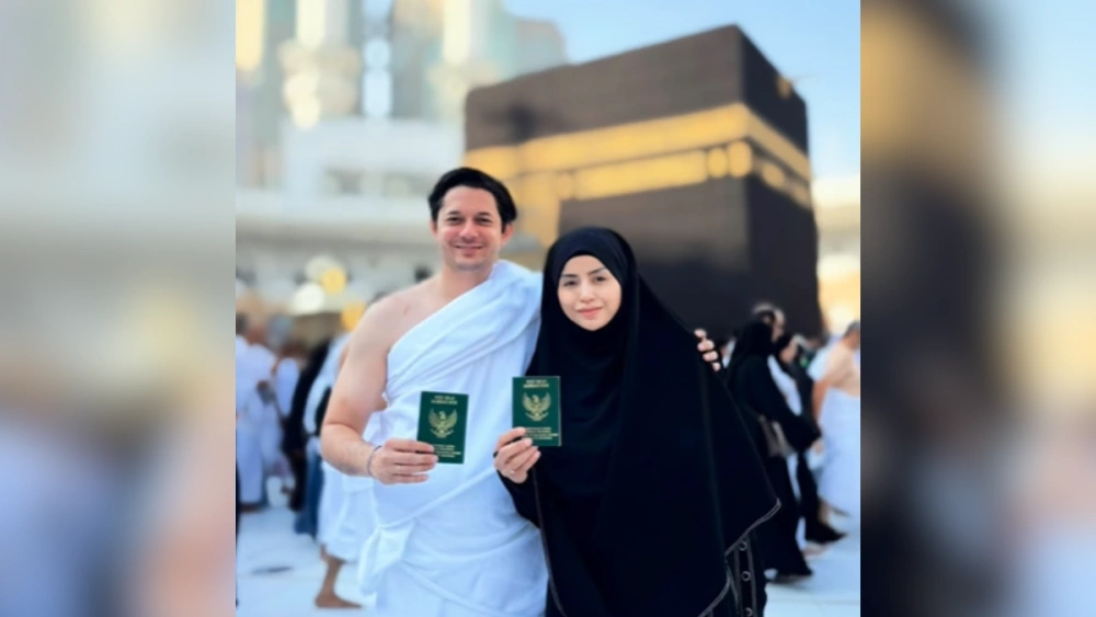 Andrew Andika dan Violentina Kaif memamerkan buku nikah dengan latar Ka'bah. [Intagram @andrewandika]